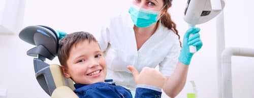 Child with doctor in the office shows thumb